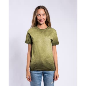 A woman stands smiling in an olive green Colortone® Oil Wash T-Shirt, paired with light blue jeans. The shirt has a branding logo.