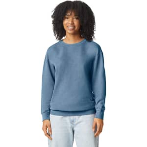 A woman models a blue Comfort Colors Lightweight Crewneck Sweatshirt, featuring long sleeves and a relaxed fit.