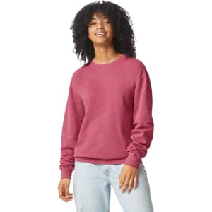 A lightweight crewneck sweatshirt in a pink hue, featuring a relaxed fit and long sleeves. It has a logo.