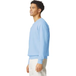 A light blue crewneck sweatshirt is displayed on a model, featuring a simple design and a logo.