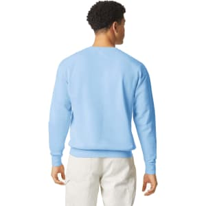 A lightweight crewneck sweatshirt in light blue, featuring a plain back and long sleeves. It has a logo on the front.