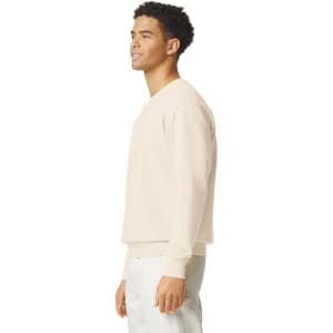 A lightweight crewneck sweatshirt in a light beige colour, displayed on a model from the side, featuring a subtle logo.