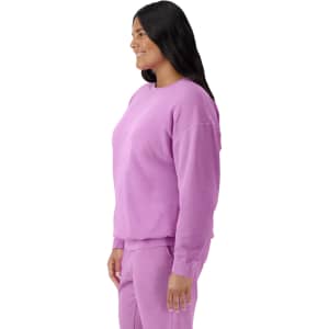 A lightweight crewneck sweatshirt in a vibrant purple, displayed on a model from the side. It features a logo.