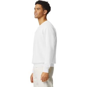 A white crewneck sweatshirt displayed on a model, featuring a logo and a relaxed fit.