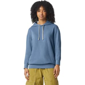 A lightweight hooded sweatshirt in blue, featuring a front pocket and a logo. The model has curly hair and is wearing cargo pants.