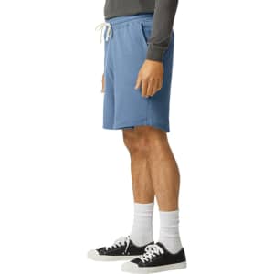 Lightweight sweatshorts in blue, featuring an elastic waistband and drawstring, styled with black sneakers and white socks.
