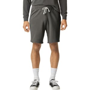 Lightweight sweatshorts in dark grey with an elastic waistband and drawstring, paired with casual footwear.