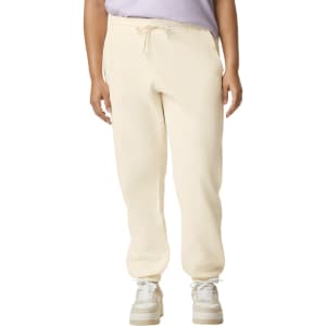 Lightweight cream-coloured sweatpants with an elastic waistband and drawstring. Features a logo on the garment.