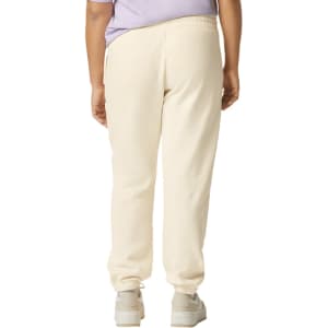 Lightweight cream-coloured sweatpants featuring an elastic waistband and ankle cuffs, with a logo on the back.