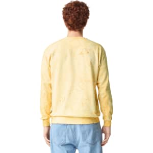 A yellow crewneck sweatshirt with a distressed look, featuring a logo on the back.