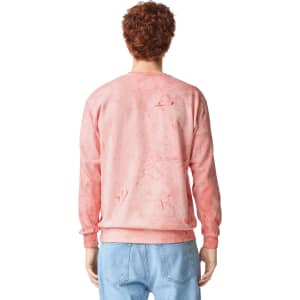 A pink marbled crewneck sweatshirt with long sleeves, featuring a logo on the back.