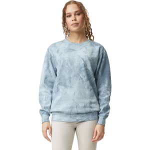 A crewneck sweatshirt in a light blue tie-dye pattern, featuring long sleeves and a logo.