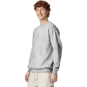 A light grey crewneck sweatshirt featuring a relaxed fit and a logo, showcased on a model.
