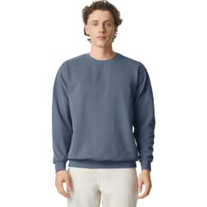 A blue adult crewneck sweatshirt with long sleeves and a plain design. Features a logo on one side.