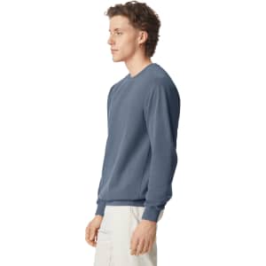 A crewneck sweatshirt in a shade of blue, featuring long sleeves and a logo.