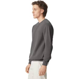 A grey adult crewneck sweatshirt displayed on a model, featuring a simple design and a logo.