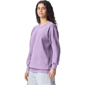 A purple adult crewneck sweatshirt featuring long sleeves and ribbed cuffs, displayed on a model.