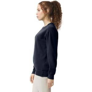A navy adult crewneck sweatshirt displayed on a model, featuring a classic fit and ribbed cuffs.