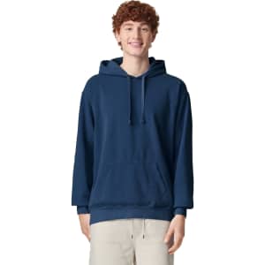 A navy adult hooded sweatshirt featuring a front pocket and a drawstring hood, worn by a smiling person.