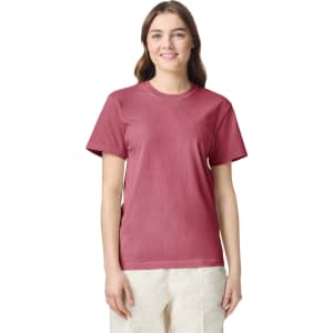 A maroon adult heavyweight T-shirt displayed on a model, featuring a round neck and short sleeves. The shirt has a logo.