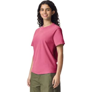 A pink heavyweight adult t-shirt featuring short sleeves and a relaxed fit, displayed on a model.