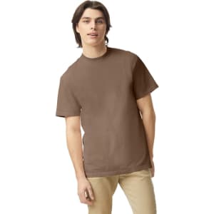 A brown heavyweight adult t-shirt on a model, featuring a casual fit and a plain design.