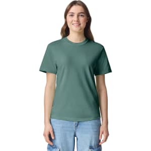 A green adult heavyweight T-shirt, featuring a crew neck and short sleeves, worn by a model.