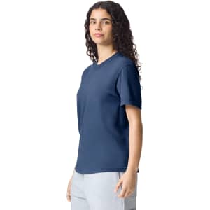 A navy adult heavyweight t-shirt displayed on a model, featuring a simple design and short sleeves.