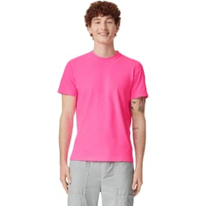 A bright pink adult heavyweight T-shirt displayed on a smiling male model, featuring short sleeves and a casual fit.