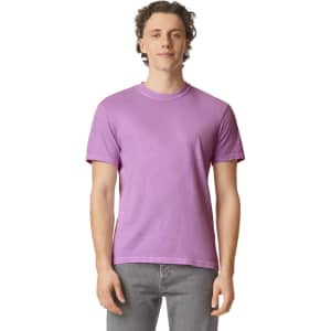 A purple heavyweight t-shirt displayed on a model, featuring a logo on the front.