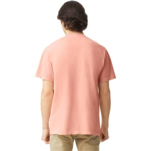 A man wearing a back view of a coral adult heavyweight T-shirt. The shirt has a plain design and short sleeves.