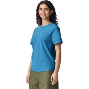 A blue heavyweight adult t-shirt displayed on a model with curly hair, featuring a simple design and logo.