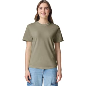 A woman wearing a short-sleeved, heavyweight t-shirt in olive green with a logo on the chest.