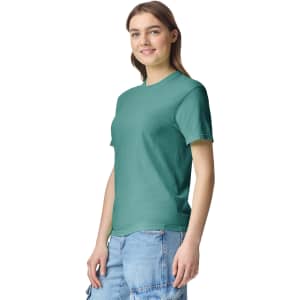 A green heavyweight t-shirt is displayed on a model, featuring a logo on the front and casual styling.