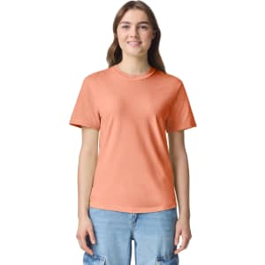 An orange heavyweight adult t-shirt displayed on a model, featuring a simple design and a logo.