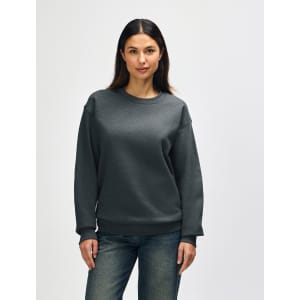 A grey Gildan Heavy Blend adult crewneck sweatshirt displayed on a model, featuring long sleeves and a relaxed fit.
