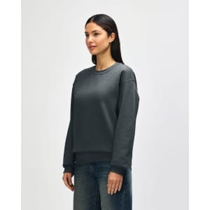 A grey Gildan Heavy Blend adult crewneck sweatshirt with a relaxed fit and long sleeves, featuring a logo.