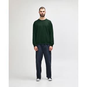 A green Gildan Heavy Blend adult crewneck sweatshirt worn by a model, paired with black jeans and sneakers.