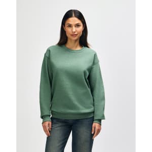 A green Gildan Heavy Blend adult crewneck sweatshirt displayed on a model, featuring long sleeves and a casual fit.