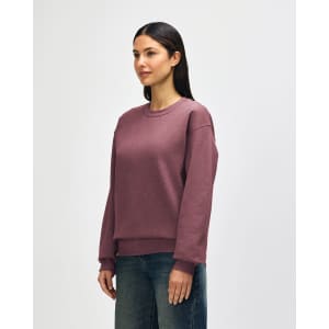 A crewneck sweatshirt in a dusty rose colour, featuring long sleeves and a relaxed fit. It has a branding logo.