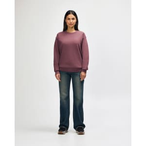 A man wearing a maroon Gildan Heavy Blend crewneck sweatshirt paired with black jeans and sneakers.