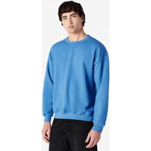 A blue crewneck sweatshirt displayed on a model, featuring long sleeves and a relaxed fit. It has a logo.