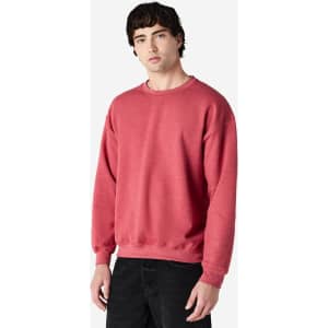 A red Gildan Heavy Blend adult crewneck sweatshirt displayed on a model, featuring long sleeves and a relaxed fit.