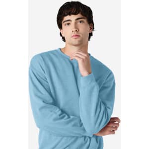 A blue Gildan Heavy Blend adult crewneck sweatshirt worn by a model, featuring a casual pose and long sleeves.