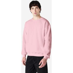 A pink Gildan Heavy Blend adult crewneck sweatshirt displayed on a model, featuring a logo.