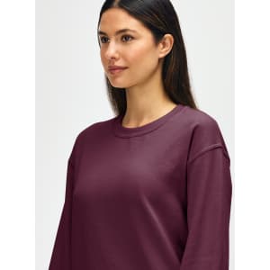 A maroon Gildan Heavy Blend adult crewneck sweatshirt with a logo, featuring a relaxed fit and long sleeves.
