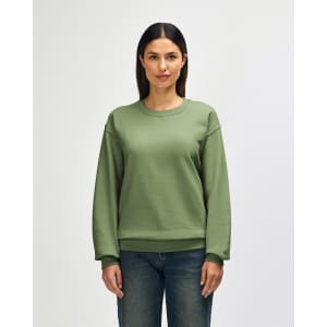 A green crewneck sweatshirt worn by a person, featuring a relaxed fit and long sleeves. It has a logo on the sleeve.