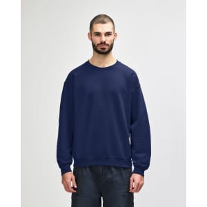 A navy blue crewneck sweatshirt with a relaxed fit, featuring long sleeves and ribbed cuffs. It has a logo.