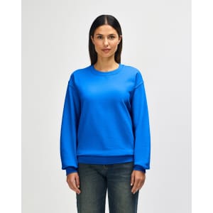 A blue Gildan Heavy Blend adult crewneck sweatshirt on a model, featuring long sleeves and a relaxed fit.