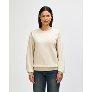 A beige Gildan Heavy Blend adult crewneck sweatshirt displayed on a model, featuring a relaxed fit and long sleeves.